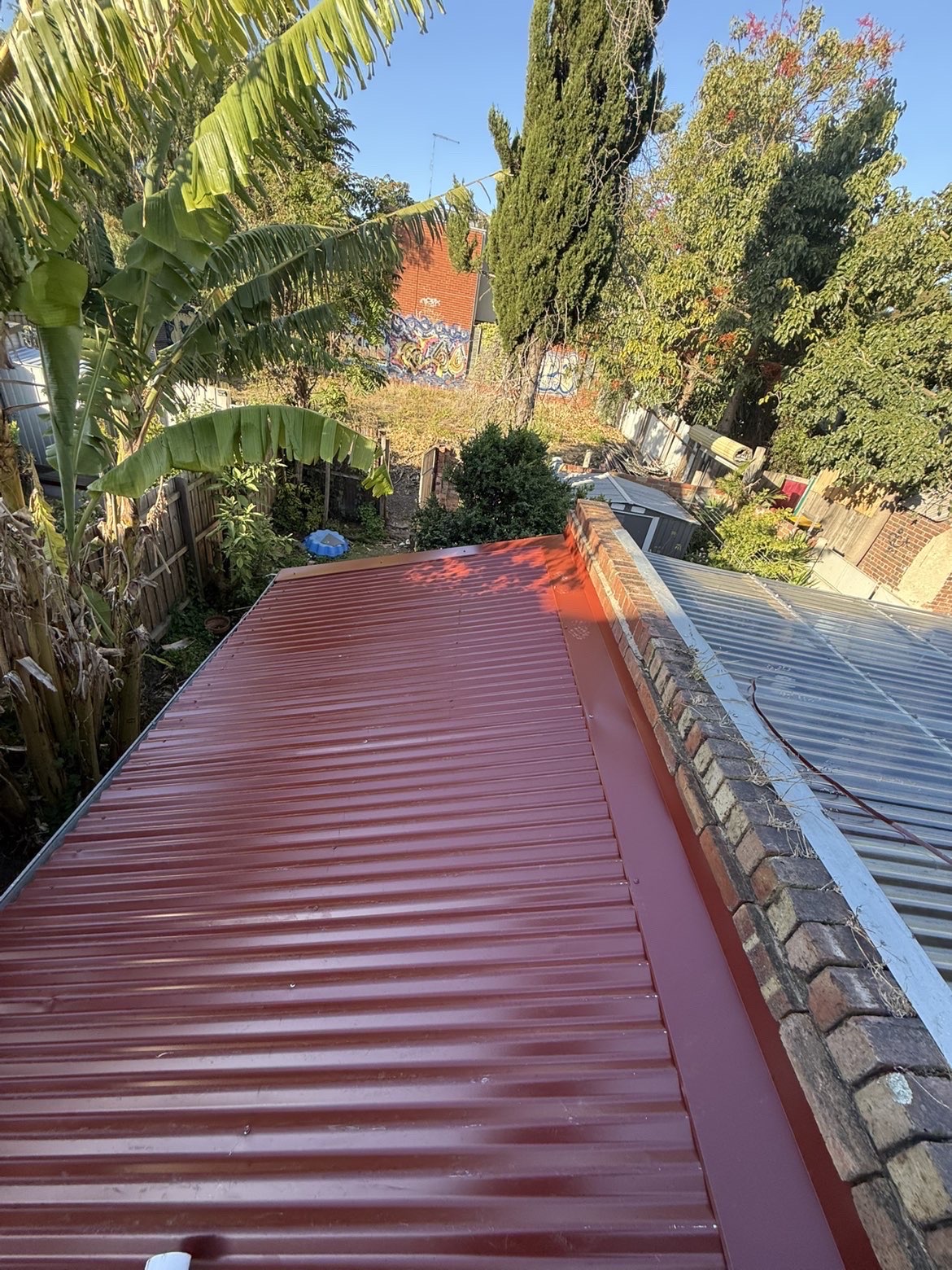 Red corrugated metal roof installed on a residential extension
