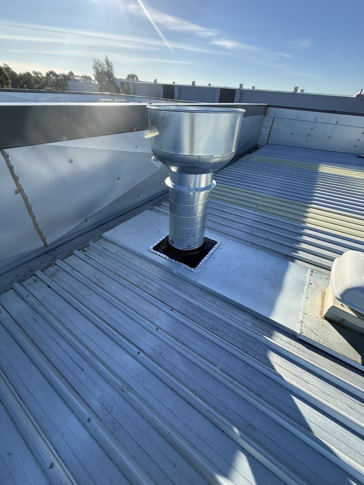 Galvanised roof vent installed on a corrugated commercial metal roof