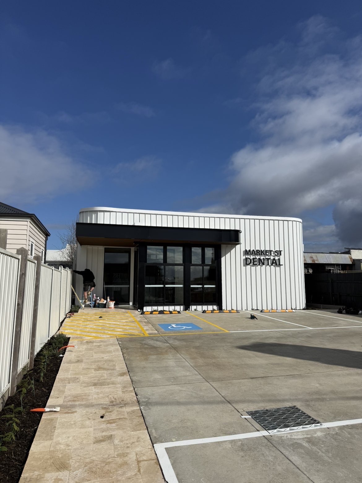 Front elevation of a commercial building with white metal cladding and black trim