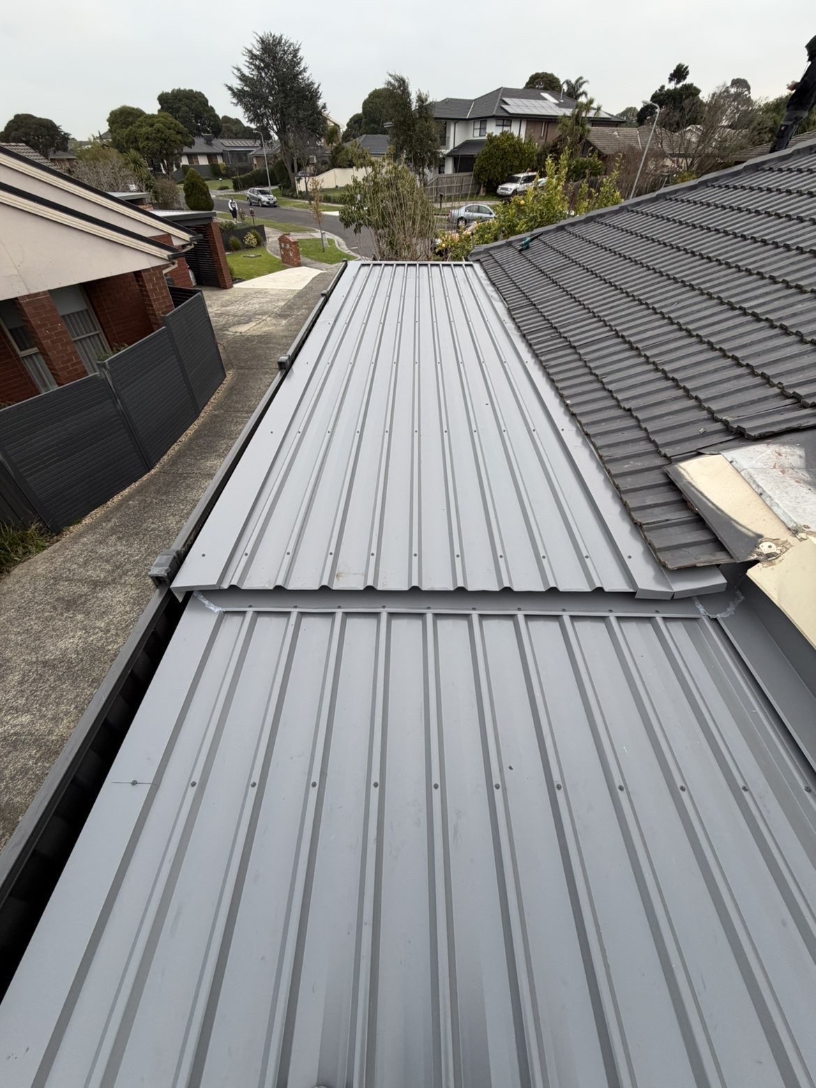 Newly installed grey metal roofing panels on a Melbourne home