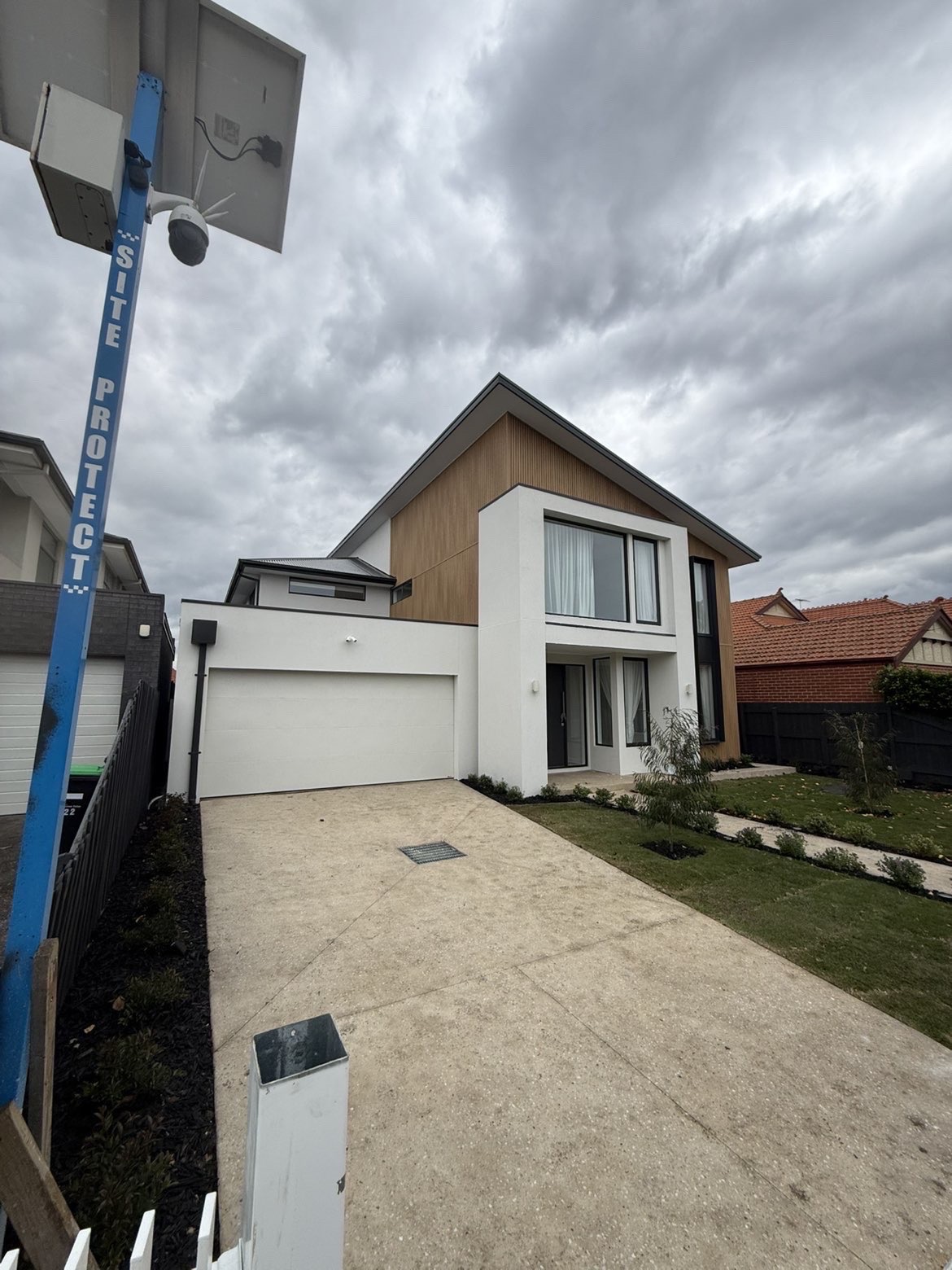 Front view of a modern Melbourne home with architectural cladding and dark metal roof
