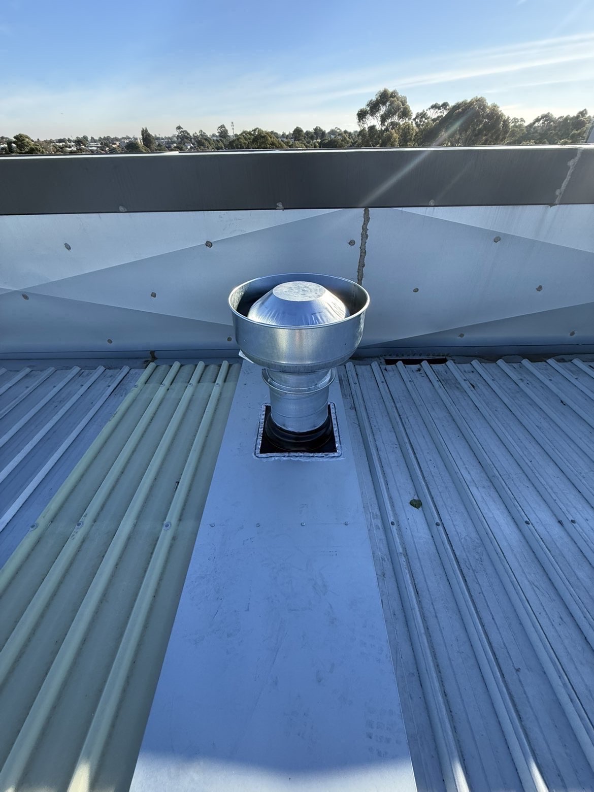 Top-down view of a circular metal roof ventilator