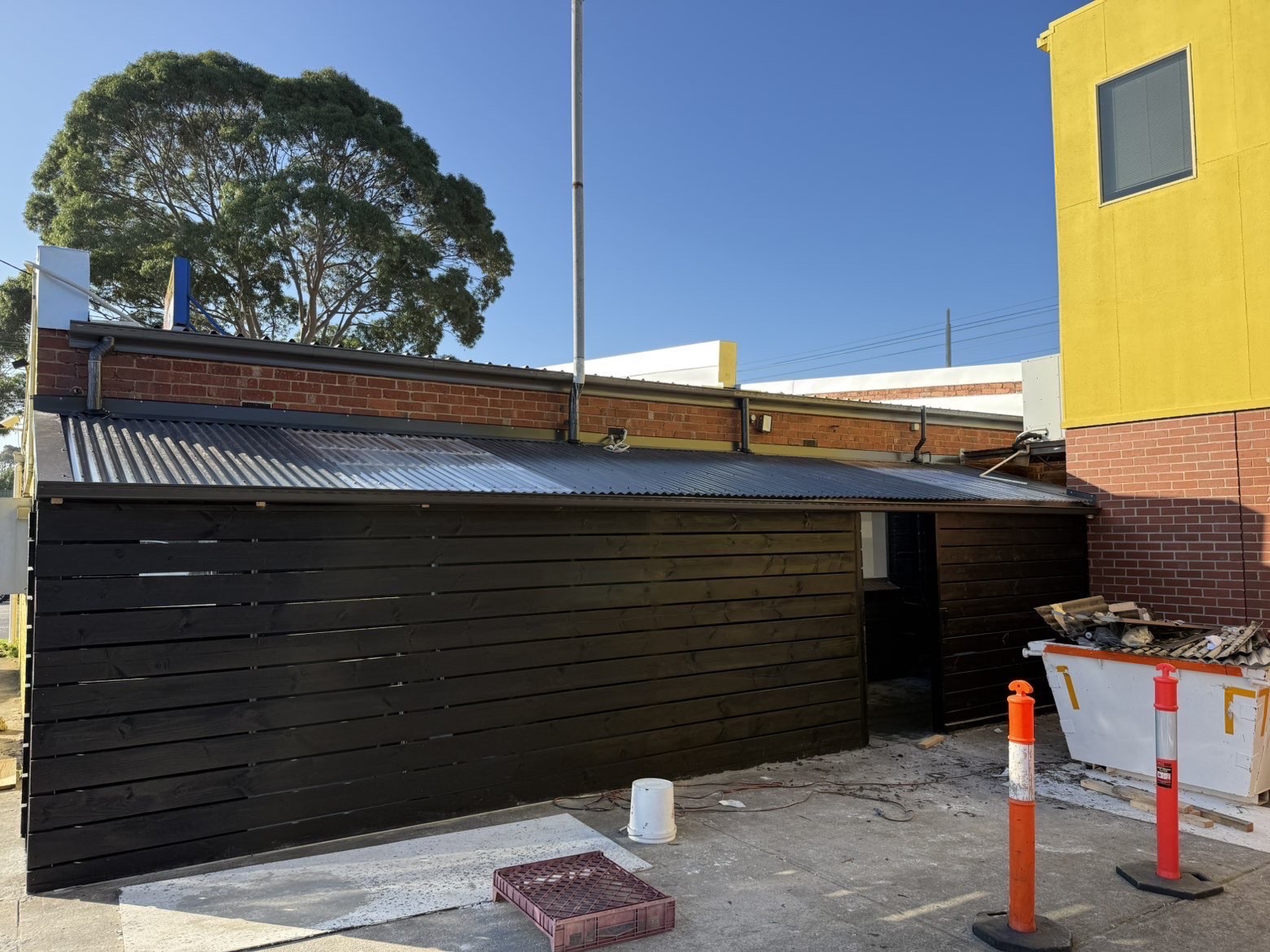 New dark guttering installed alongside metal roofing